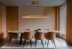 a dining room table with six chairs and a light fixture hanging over it's head