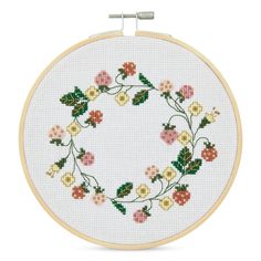 a cross stitch pattern with flowers and leaves in the center, on a white background