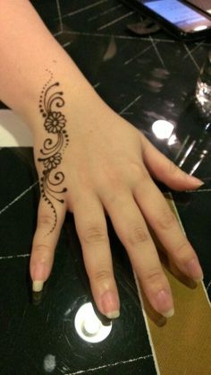 a woman's hand with a henna tattoo on it