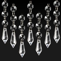 several clear glass beads hanging from a black background