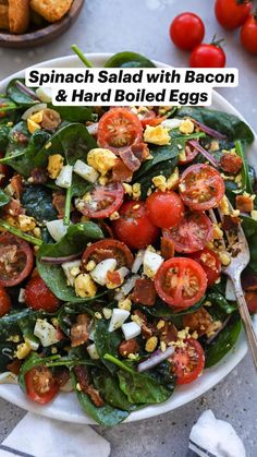 spinach salad with bacon and hard boiled eggs in a white bowl on a table