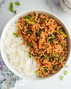 a bowl filled with rice and broccoli on top of a white countertop