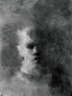 a black and white photo of a man's face in the fogy sky