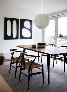 a dining room table with four chairs and a lamp hanging from the ceiling above it