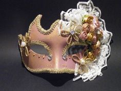 Handmade Venetian Masquerade mask covered in Old Rose Paint. Eyes are outlined with gold braid, gold paint beading and crystal rhinestones. The left side of the mask is the most elaborate part of the mask and is covered with fabric flowers in the same tones of the mask, pearls, lace and pearl beads.  It is outlined with gold trim for an exquisite finish. Can come with a ribbon covered stick to hold from or tie back ribbons. This type of mask would look lovely on any Bride for a Venetian Masquera Venetian Masks And Prosthetics For Wedding And Mardi Gras, Gold Wedding Mask, Rose And Gold Wedding, Masquerade Mask Lace, Masquerade Mask Ideas, Harlequin Mask, Wedding Masquerade, Mardi Gras Masquerade, Venetian Masquerade Masks