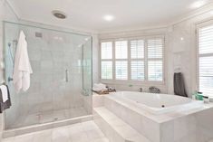 a bathroom with a large bathtub next to a walk in shower