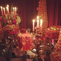 a table topped with lots of different types of cakes and desserts covered in candles