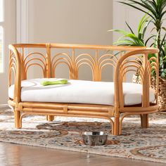 a dog bowl is sitting on the floor next to a bamboo bench with white cushions