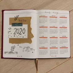 an open notebook with a calendar on the page and writing in it, sitting on a wooden table