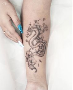 a woman's arm with a dragon tattoo on the left side of her leg