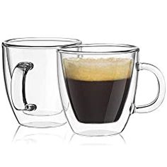 two glass mugs filled with liquid sitting next to each other on a white surface