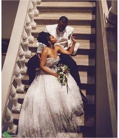 a bride and groom are sitting on the stairs