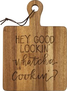 a wooden cutting board with the words hey good looking whatcha's cooking? on it