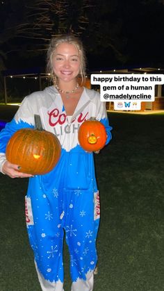 a woman holding two pumpkins in her hands