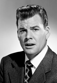 a black and white photo of a man in a suit with a surprised look on his face