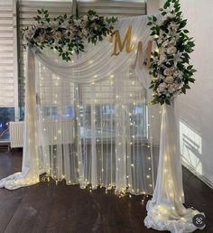 a wedding arch decorated with white flowers and greenery