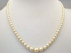 Hello and welcome to my shop.              I am offering to you this beautiful quality single row of vintage 1960's / 70's period faux pearl necklace. As you will see in the pictures the necklace is handmade in a single row of shiny polished graduated rich cream coloured faux pearl beads. The necklace clasp is a silver tone and diamante set push in type in good working order.  This fine single strand pearl necklace is in an excellent used vintage condition with just slight age related surface we Classic Cream Necklaces With Round Beads, Formal Cream Beaded Necklaces, Formal Cream Beaded Necklace, Formal Cream Single Strand Pearl Necklace, Formal Single Strand Cream Pearl Necklace, Cheap Vintage Pearl White Necklace, Cream Single Strand Pearl Necklace, Vintage Pearl White Pearl Necklace, Vintage Pearl White Round Necklaces