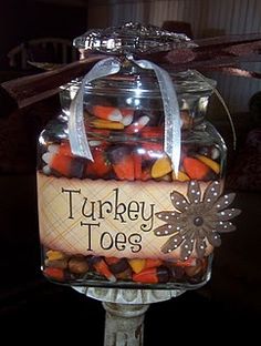 a glass jar filled with candy and candies sitting on top of a metal stand