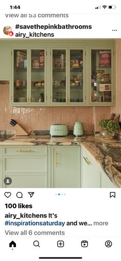 an instagramted photo of a kitchen with green cabinets and pink marble countertops