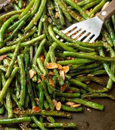 asparagus and almonds in a skillet with a spatula