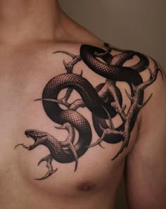 a man's chest with a snake tattoo on it