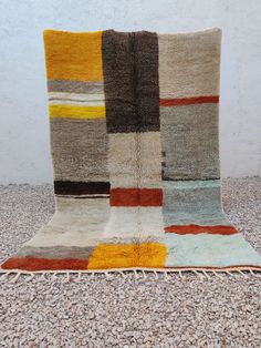 a multicolored patchwork rug with fringes on the bottom and one side