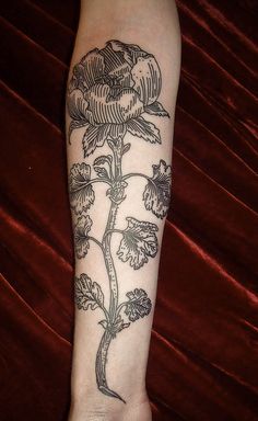 a woman's arm with a flower tattoo on it