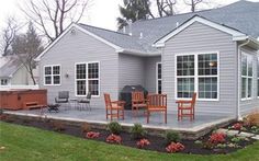 a house with a patio and hot tub next to it's back yard area