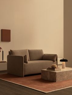 a living room with a couch, table and lamp on the floor in front of it