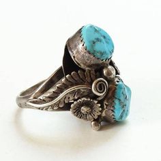 This is an Old Navajo Double Turquoise Ring Intricate Appliques Size 7.25 Sterling Silver C1970s. This size 7.25 Native American ring includes two polished turquoise stones (one with pyrite inclusions) surrounded by intricate twisted wire and appliques. The ring acid tests positive for sterling silver. The face measures 1 inch, and the ring weighs 9.1 grams. 2235635 More Native American Jewelry https://www.etsy.com/shop/redroselady?ref=hdr_shop_menu&section_id=15506102 More Southwestern Jewe Vintage Concho Ring Jewelry, Vintage Adjustable Concho Rings, Vintage Blue Concho Ring, Antique Turquoise Adjustable Rings, Adjustable Vintage Turquoise Ring, Adjustable Vintage Turquoise Ring As Gift, Adjustable Vintage Turquoise Ring For Gift, Vintage Turquoise Concho Ring, Vintage Handmade Turquoise Ring Collectible