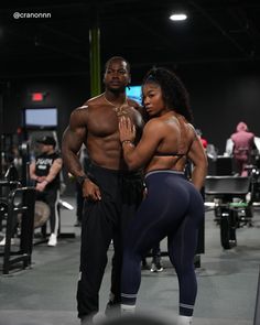 a man and woman standing next to each other in a gym