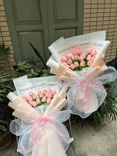 two bouquets with pink roses are sitting in front of a door