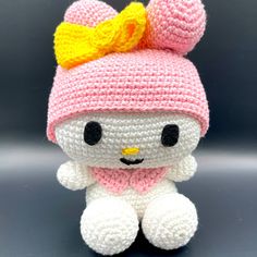 a crocheted hello kitty doll with a pink hat and scarf on it's head