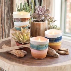 candles and succulents are arranged on a table