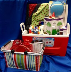 a red suitcase filled with baby items on top of a blue cloth covered flooring