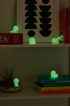 some books are sitting on a shelf with glowing lights in the shape of ghostes