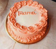 a cake with the word mom written on it sitting on a white cloth covered table