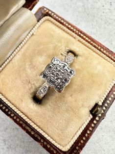 This is a beautiful 1920s 18ct Gold & Platinum Diamond Square Cluster Ring. This gorgeous ring is a stunning vintage piece from the 1920s. A sparkling diamond is set in the centre of the platinum setting, while 8 further sparkling diamond accents are set around the edge of the square face of the ring. The diamonds have been tested and confirmed as natural Ring size P Face of the ring measures 7mm x 7mm approximately. Marked 18ct and PLAT for 18ct Gold and Platinum but partially rubbed. Please no Antique Brilliant Cut Diamond White Ring, Antique Brilliant Cut Diamond White Diamond Ring, Victorian Platinum Diamond Ring With Hallmark, Victorian Platinum Diamond Ring Hallmarked, Antique Diamond White Diamond Ring With Brilliant Cut, Antique Diamond White Diamond Ring, Vintage Diamond Rings In Diamond White, Antique Brilliant Cut Diamond White Cluster Ring, Vintage Diamond Ring With Rose Cut Diamonds For Anniversary