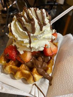 a waffle topped with whipped cream and strawberries