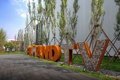 the word love spelled out in front of a building with lots of trees and grass