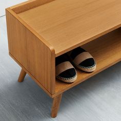 a pair of shoes that are on top of a wooden shelf in front of a table