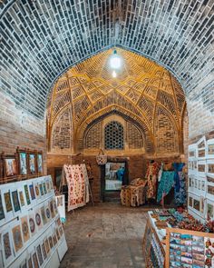 the inside of an old building with pictures on display and paintings hanging up in it