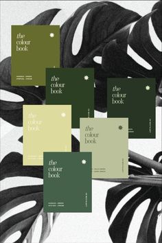 the color book is on display in front of some green and black leaves, with white lettering