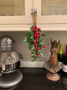 a kitchen counter with wine bottles and an angel statue hanging from it's side