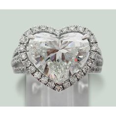 a heart shaped diamond ring with diamonds surrounding it