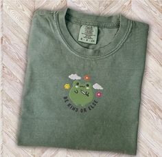 Super fun EMBROIDERED frog premium vintage style t-shirt. If you're looking for a thick, structured tee that's also super soft and breathable--look no further! The unisex garment-dyed heavyweight t-shirt ticks all the boxes and is made of 100% ring-spun cotton. The regular t-shirt style will complement most looks and fit you to a tee. * 100% ring-spun cotton * Fabric weight: 6.1 oz/yd² (206.8 g/m²) * Garment-dyed * Relaxed fit * 7/8″ double-needle topstitched collar * Twill-taped neck and shoulders for extra durability * Double-needle armhole, sleeve, and bottom hems * Blank product sourced from Honduras This product is made especially for you as soon as you place an order, which is why it takes us a bit longer to deliver it to you. Making products on demand instead of in bulk helps reduce Frog Merch, Frog Shirt Aesthetic, Frog Shirt, Frog Tshirt, Frog Clothes Sweatshirts & Hoodies, Soft Boy Aesthetic, Frog And Toad Shirt, Frog Tee Shirt, Frog Meme