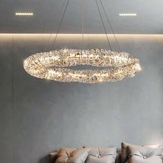 a modern chandelier hangs from the ceiling above a bed in a room with gray walls