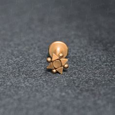 an image of a pair of gold earrings on the floor in front of a black background