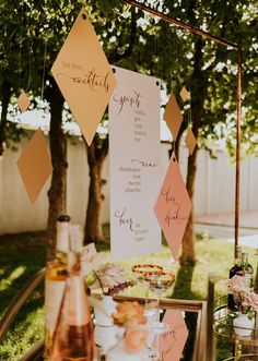 a table topped with lots of food and drinks next to a forest filled with trees