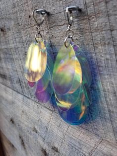 "These stunning iridescent dangle earrings light up your world and face! They are upcycled from the process of making our sequin kimonos. This is an effort toward being zero waste and more sustainable. Savior Scraps. Measure 1.5 inches long including hooks. This pair features a cluster of translucent iridescent sequins! Please select \"clear\" in the color options for this pair." Unique Iridescent Earrings For Party, Handmade Iridescent Drop Earrings, Bohemian Iridescent Earrings With Ear Wire, Bohemian Iridescent Dangle Earrings, Handmade Iridescent Dangle Earrings, Handmade Unique Iridescent Earrings, Handmade Bohemian Iridescent Earrings, Bohemian Handmade Iridescent Earrings, Whimsical Iridescent Earrings With Ear Wire